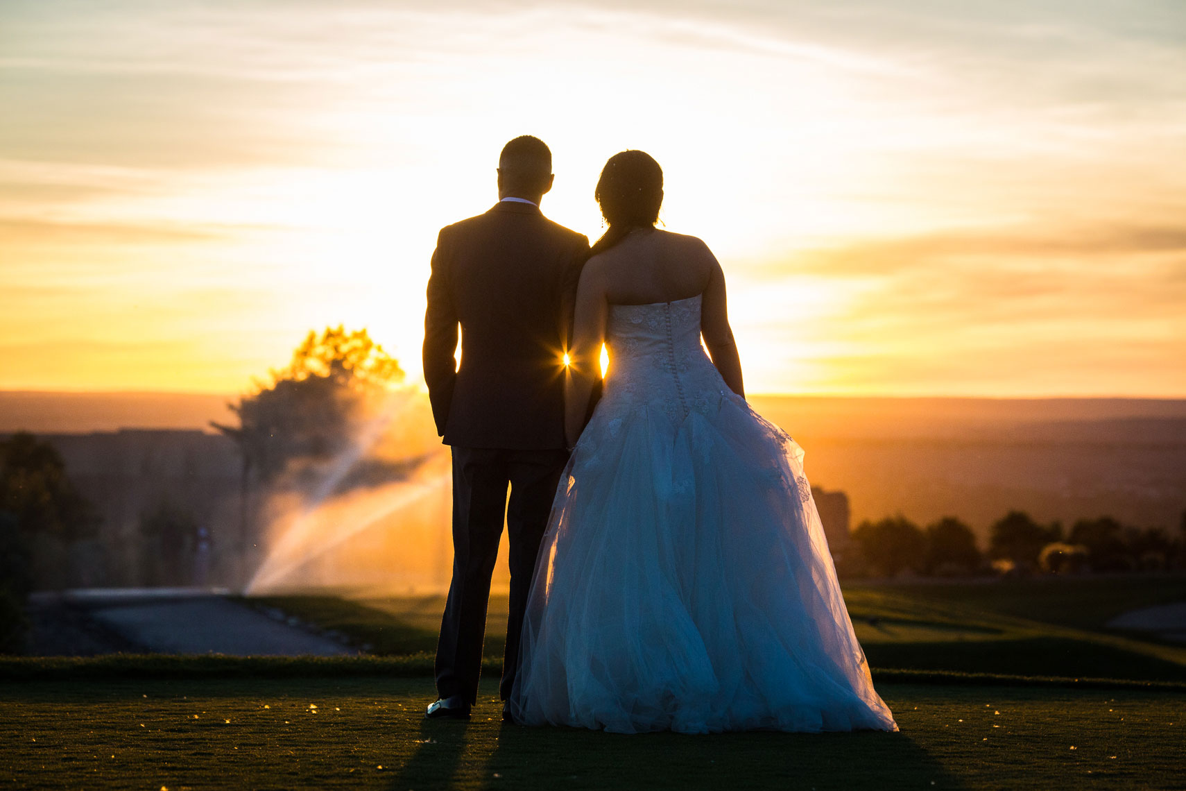 Sandia Resort Wedding at sunset with the sprinkler system blocking the way back for the bride and groom