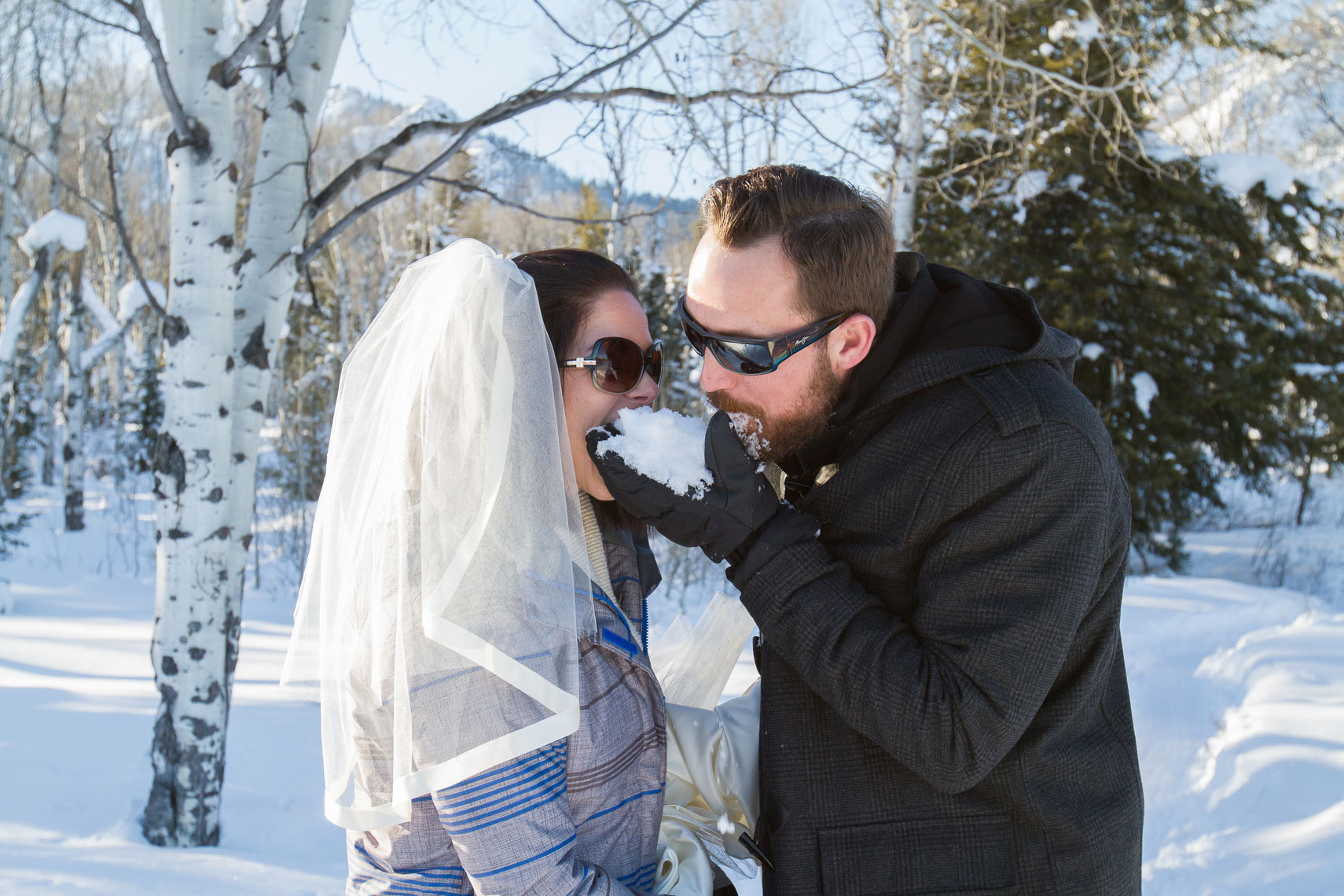 Grand Teton winter wedding, couple eating snow instead of cake